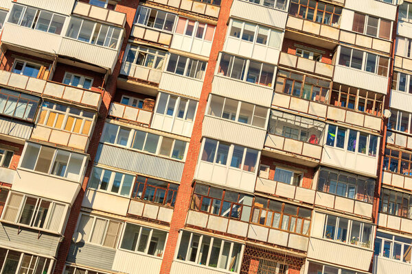 Tilted photo with a large number of balconies on the wall of a multi-storey building. balcony of different design and glazing ugly design of the city