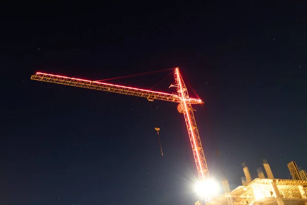 Iluminado por cintas led rojas flecha en la grúa torre por la noche —  Fotos de Stock