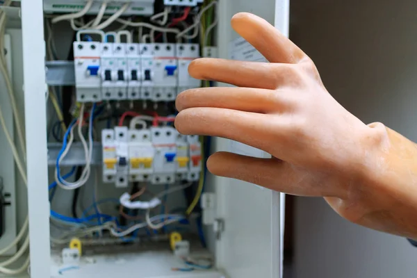 Worker in rubber gloves opens the door switchboard — Stock Photo, Image