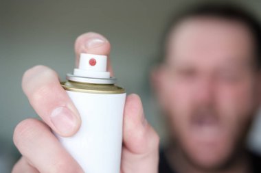 elinde sprey ile adam, ön planda koruma spreyi