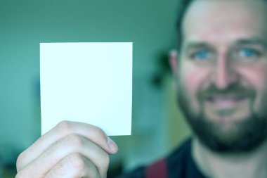 adam elinde boş bir kağıt bir sayfa tutar ve gülümsüyor