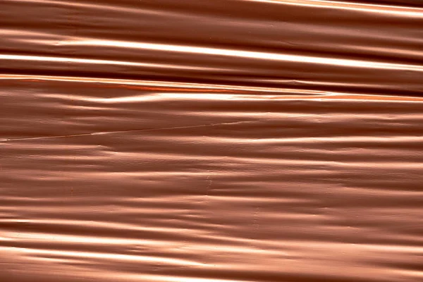 Many wrinkles and folds on a copper foil background — Stock Photo, Image