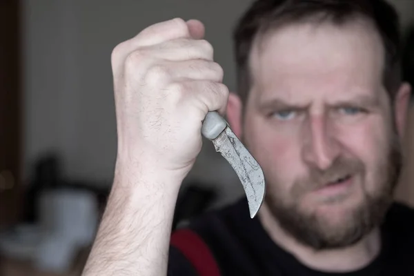 An angry man with a curved knife in his hand — Stock Photo, Image