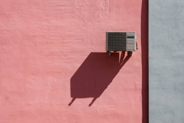 Duvarda klima asılı soyut bir fotoğraf ve uzun bir gölge