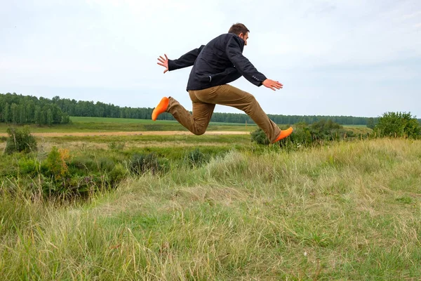 a man running across the field in orange socks jumped high with joy. striding across the field