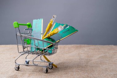 RAM ve internet kablosunun katlandığı bir süpermarket arabası. İnternet erişimi için bilgisayar aksesuarları satın almak