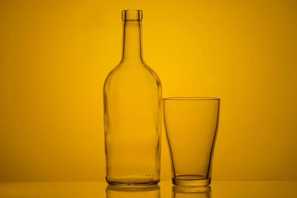 Foto Una Bottiglia Bicchiere Con Retroilluminazione Sfondo Giallo Vetro Vuoto — Foto Stock