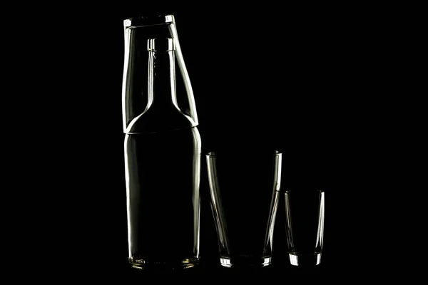 Abstract glass objects on a table. Black background. bottle on her glass and piles