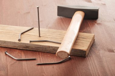 Tahtada çivi ve çekiç var. Nasıl çalışacağını bilmeyen insanlar kavramı.