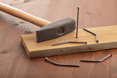 Çivi çakmayı çok iyi bilmeyen biri. Biri tahtaya sıkıştı. Çivi kavramı, insanların devletten malzeme olarak gelmesidir.