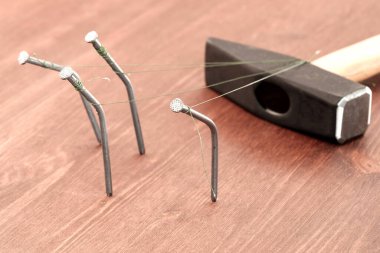 Kavisli çiviler masanın üzerinde duran bir çekice bağlıdır. Sosyal adaletsizlik kavramı çalışan insanlar zenginleri sürüklüyor