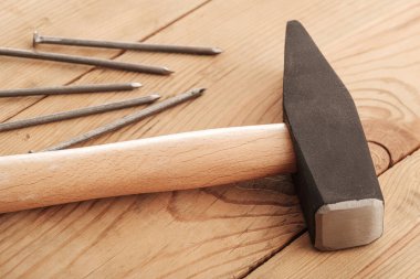 Tahta bir dokuda beş çivi ve bir çekiç. Marangozluk atölyesi marangozluğu bırakmış.