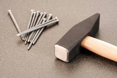 Seramik yüzeyde büyük metal çekiç ve çiviler. Sayı yapmaya hazır