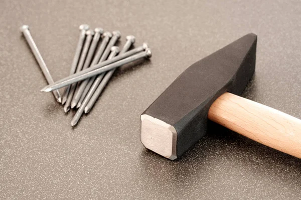 Seramik yüzeyde büyük metal çekiç ve çiviler. Sayı yapmaya hazır