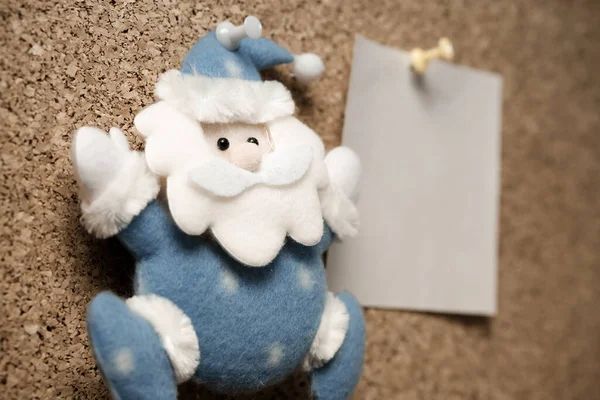 Santa Claus toy on the wall and stickers for inscriptions out of focus. New Year's list