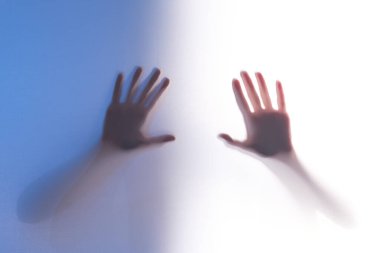 Kızın avuçlarındaki silüet, tavan penceresinin arkasından aydınlanıyor. renk ayrımı iki yarı mavi ve beyaz