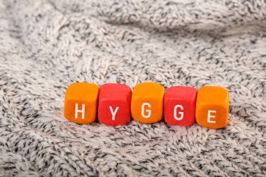 Hygge, örülmüş bir yüzeye yerleştirilmiş plastik küplere yazılmıştır. konfor ve konfor
