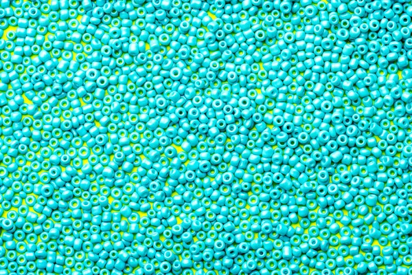 blue beads are scattered over the surface. close-up of beads