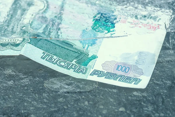 Buz kaplı Rus rublesi kağıt banknotları. Ruble dondu ve değeri düştü.