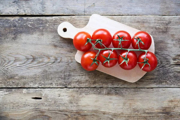 Ramo Tomates Cereja Maduros Uma Tábua Madeira — Fotografia de Stock