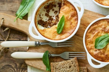 Ahşap arka plan üzerinde beyaz kaselerde Çoban pasta                               