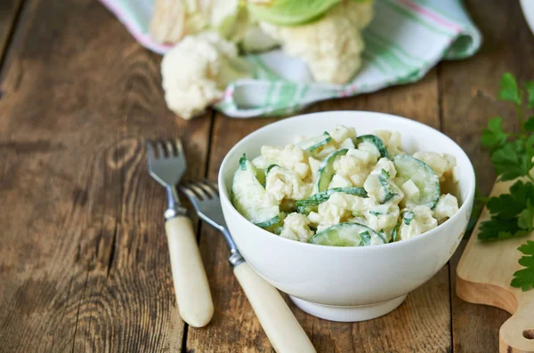 Ahşap bir arka plan üzerinde salatalık ve yumurta ile Karnabahar salatası                               