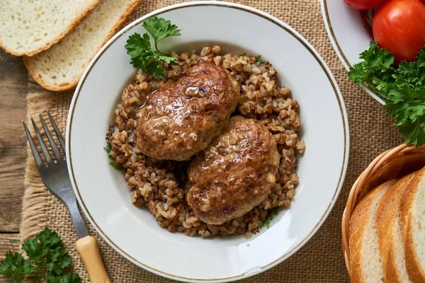 Beyaz bir kapta karabuğday ile kızarmış et pirzola                               