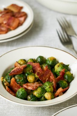 Beyaz bir kapta pastırma ile kızarmış brüksel lahanası                               