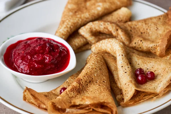 Beyaz tabakta yaban mersini soslu krep.                               