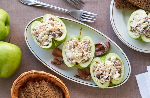 Raw apples stuffed with herring and eggs