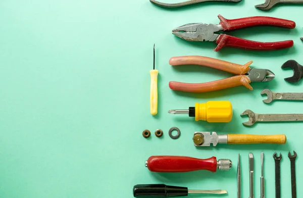 Flat lay of repair tools on a mint background