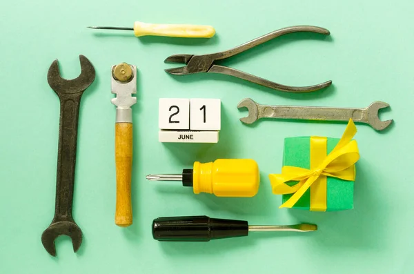Flat lay for father\'s day with tools and gift box on a mint background