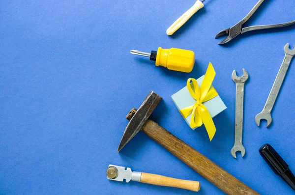 Flat lay for father\'s day with tools and gift box on a blue background