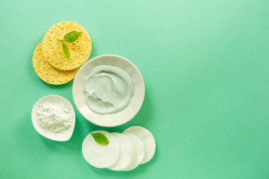 Kâselerde yüz kilinden maske ve nane arkaplanındaki bakım maddeleri