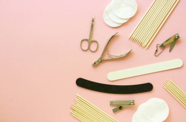 Pembe arka planda manikür ve pedikür aletleri. Metin için boşluk