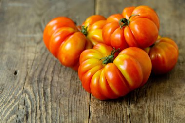 Eski ahşap arka planda olgun kırmızı domates yığını