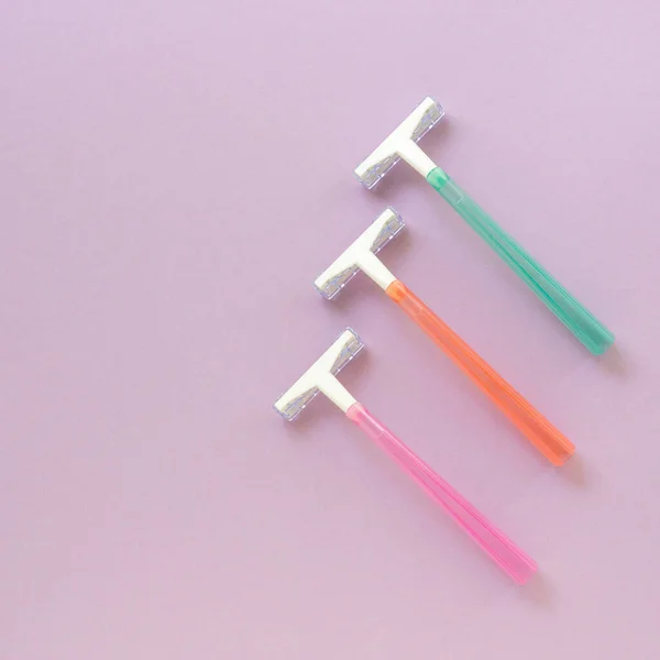 Multicolored disposable razors for depilation on a lilac background