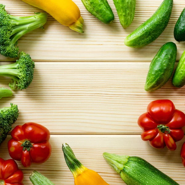 Hafif ahşap arka planda çeşitli sebzelerin çerçevesi. Metin için boşluk