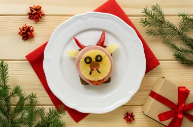 Sosisli, ananaslı ve boğa şeklinde sebzeli komik bir sandviç. Şenlikli kahvaltı ya da çocuklar için öğle yemeği. 2021 yılının sembolü.