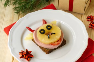 Sosisli, ananaslı ve boğa şeklinde sebzeli komik bir sandviç. Şenlikli kahvaltı ya da çocuklar için öğle yemeği. 2021 yılının sembolü.