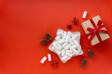 Kırmızı zemin üzerinde beyaz şekerleme ve noel süslemeleri, metin için boşluk