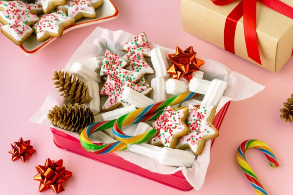 圣诞或新年礼品盒 内附姜饼 棉花糖和棒棒糖粉背景 — 图库照片