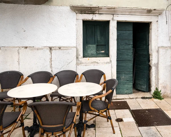 Bir Kafeterya masaları boş, eski yeşil ahşap kapı Cres (Hırvatistan) baharda açın.