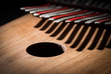 Bir başparmak piyanoyla (Kalimba, Mbira) gümüş ve kırmızı çatalın dişlerini ayrıntılarını