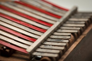 Bir başparmak piyanoyla (Kalimba, Mbira) gümüş ve kırmızı çatalın dişlerini ayrıntılarını