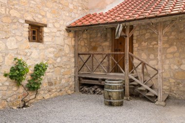 Eski bir ev, bir bahçede su popo olarak kullanılan eski şarap varil