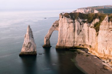 Chalk cliffs of Etretat (Normandy France) with the natural arch Porte d'Aval and the stone needle called L'Aiguille clipart