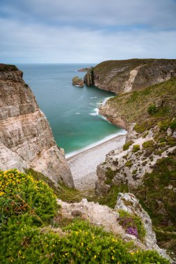 Cap Frehel, Pointe du Jas, küçük muhteşem kayalıklarla plaj ve bulutlu bir günde yaz (Brittany, Fransa Amas du Cap ada)