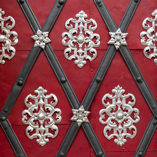 Крупный план красивого серебряного украшения на красной двери
