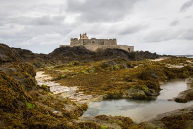 Plaj ve bulutlu bir günde yaz aylarında Saint Malo'da (Bretagne, Fransa) düşük gelgit sırasında Fort Ulusal